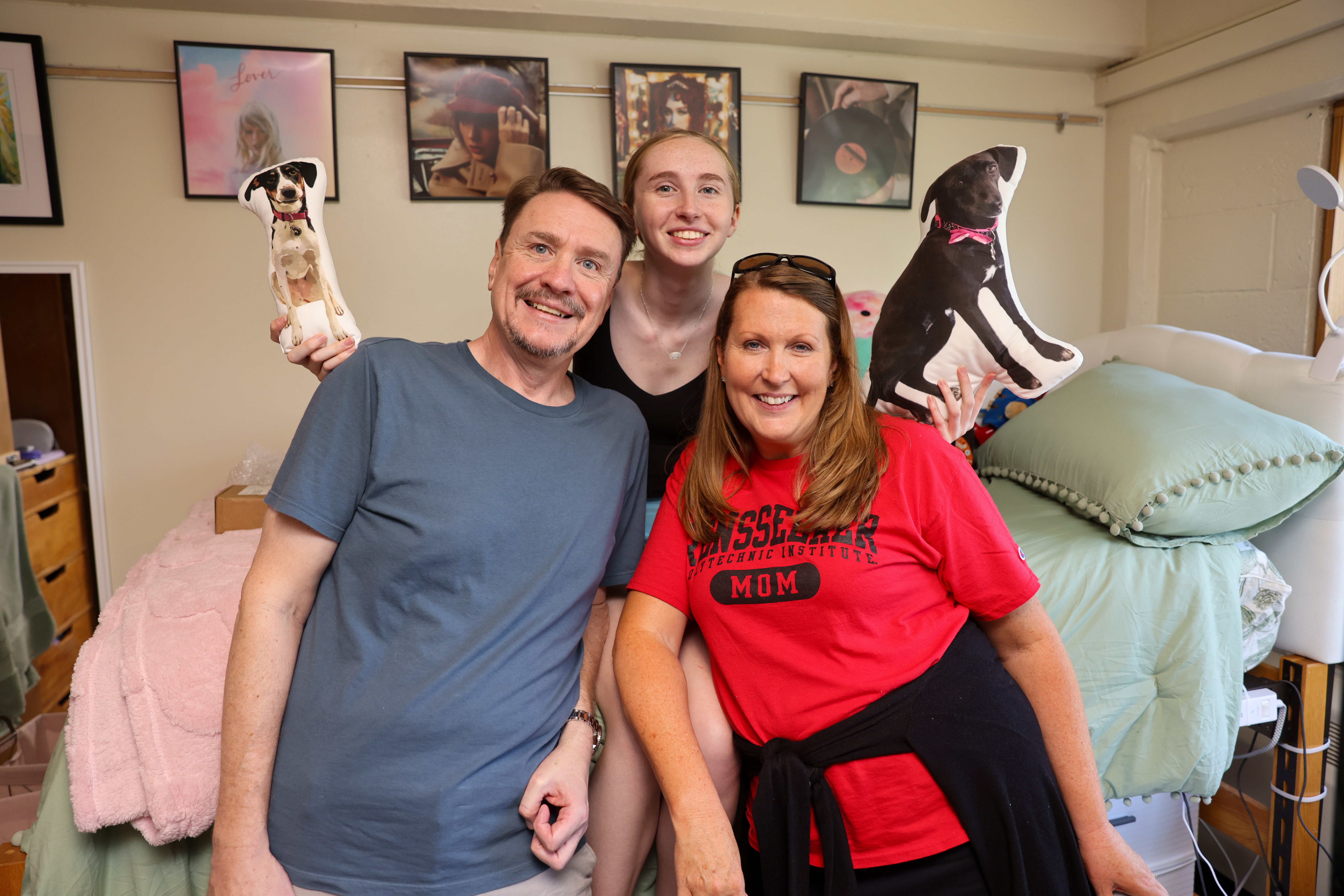 Student smiling with parents in residence hall room