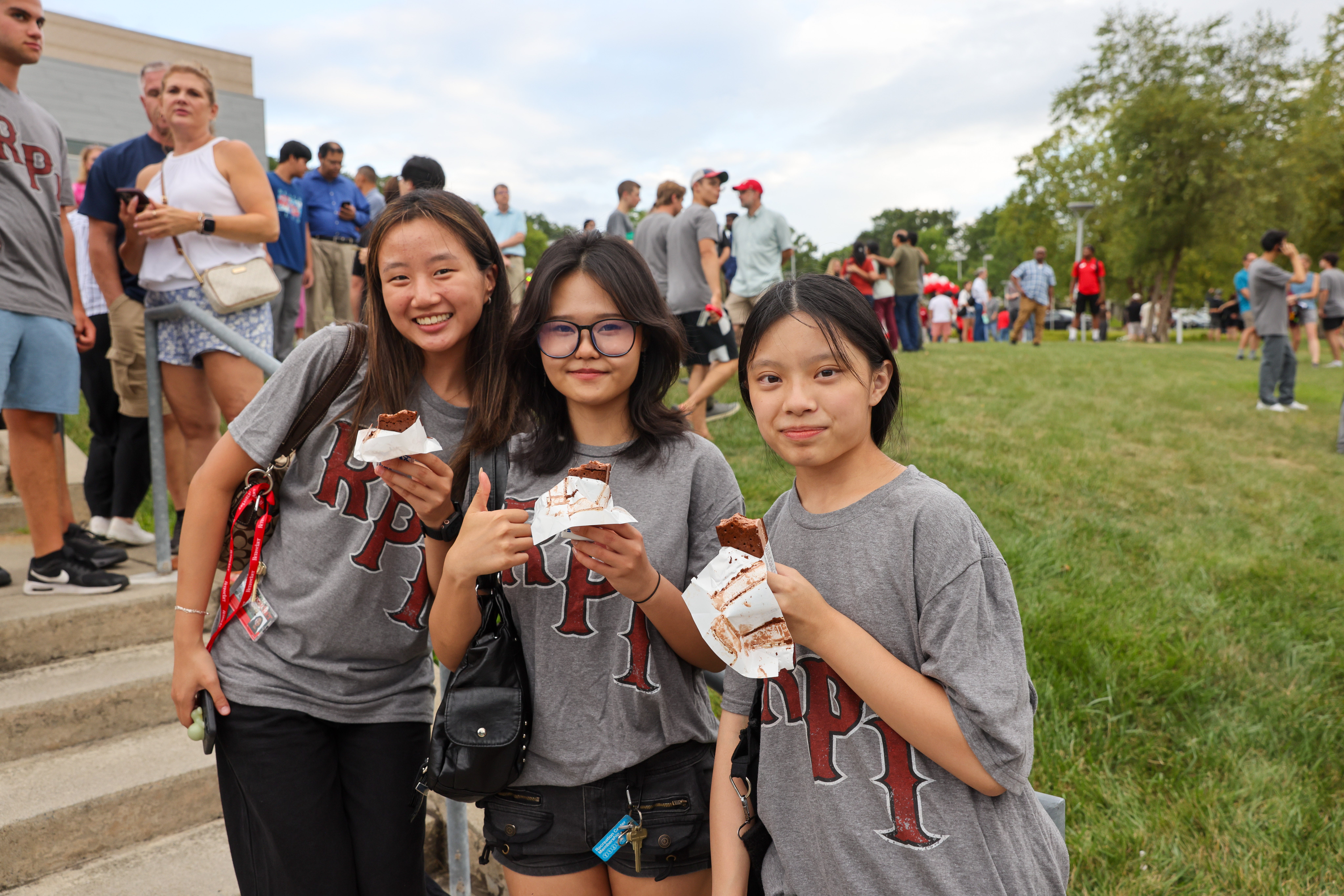Three students smiling and eating ice cream at Class Photo Reception