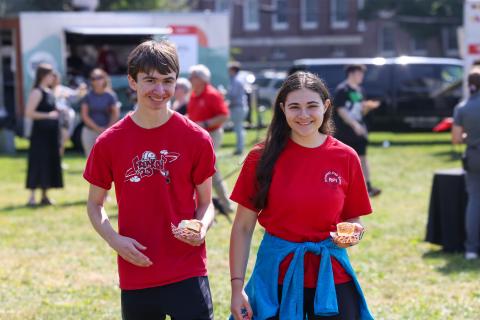 Two students walking in red shirts at RPI carnival