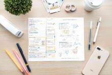 Planning calendar on a desk with other supplies around it.