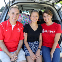 Parents with daughter sitting in the back of the car during move-in