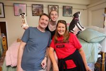 Student smiling with parents in residence hall room