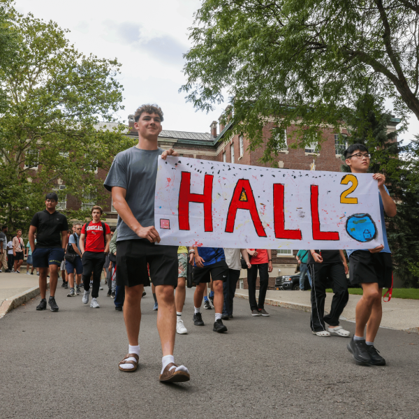 Students holding Hall residence hall banner 